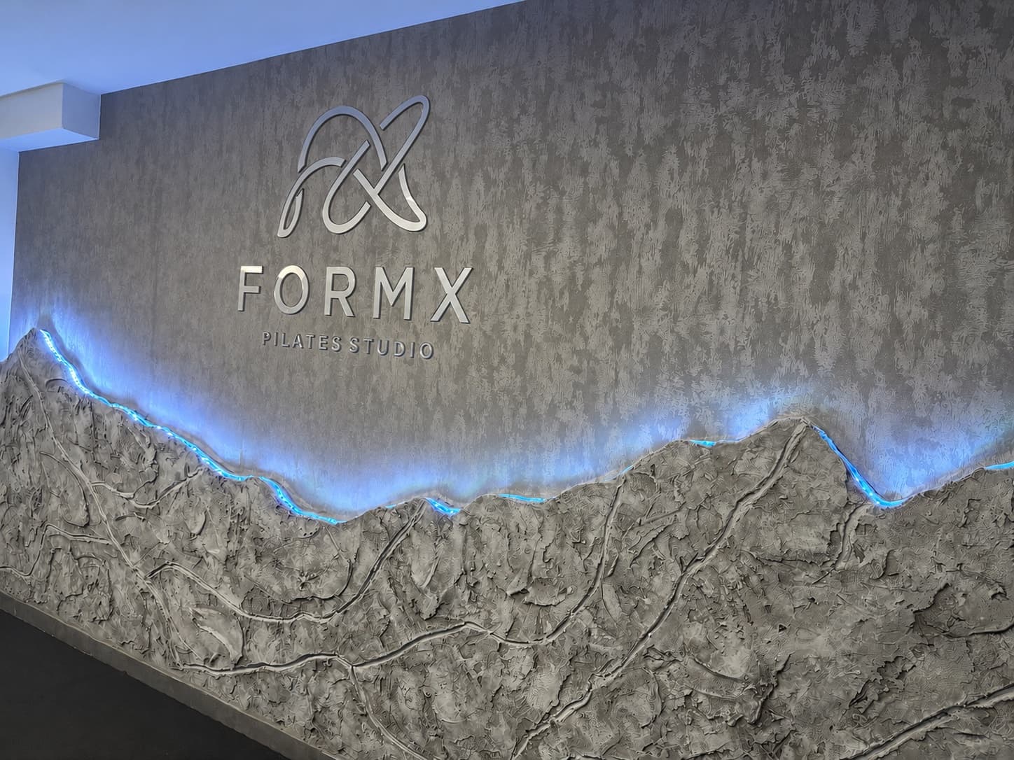 A FormX Pilates Studio logófala kék LED-fénnyel